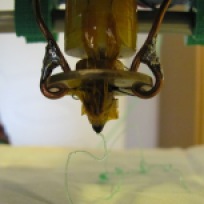 Yet another close-up of the working extruder. The solder which reinforces the copper wire did not show signs of melting from the high temperatures, as it is futher away from the tip, with a large area exposed to the air.